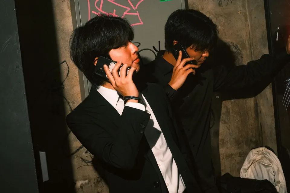 rom&BAAWLA in suits, talking on their phones