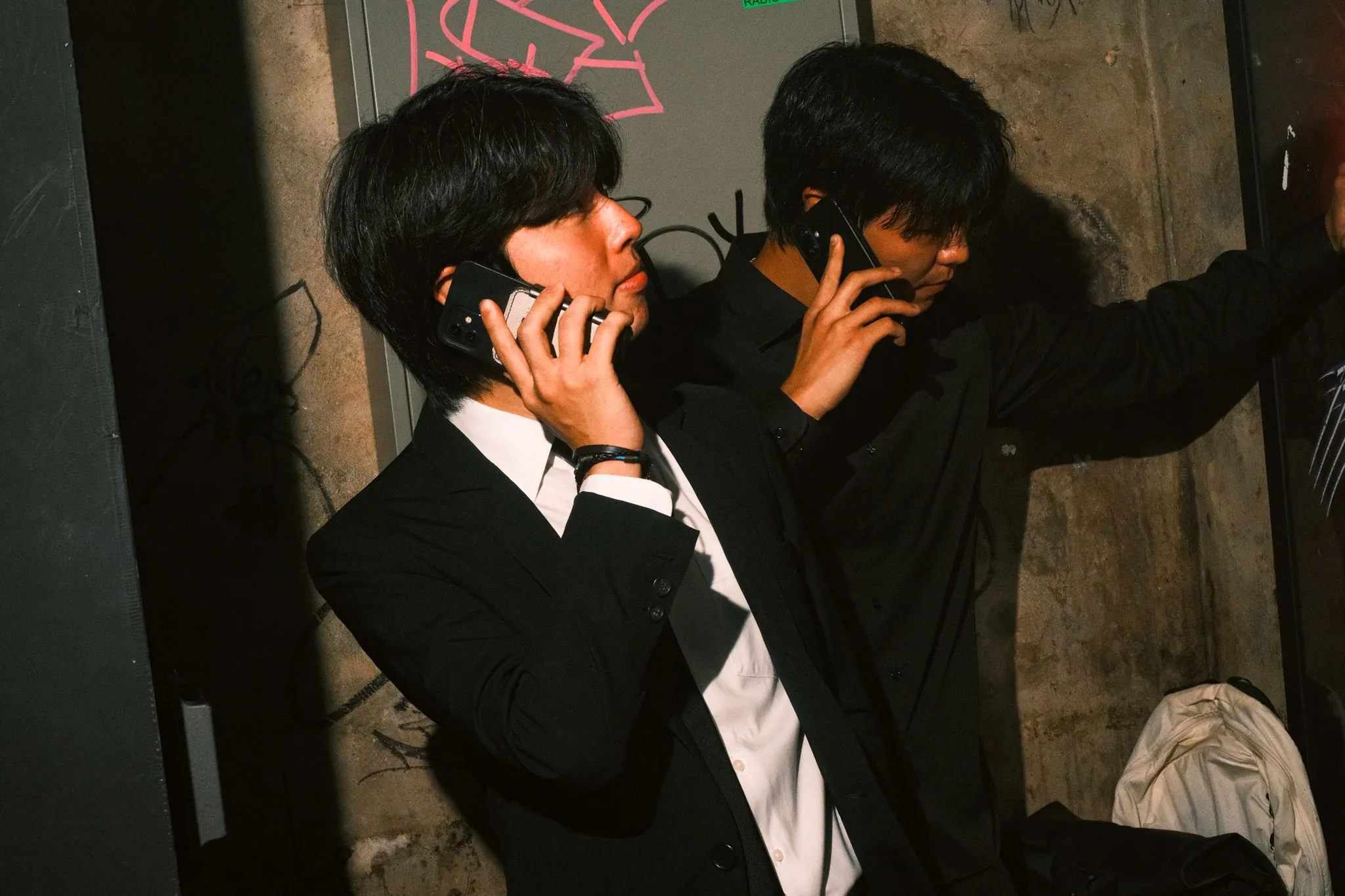 rom&BAAWLA in suits, talking on their phones